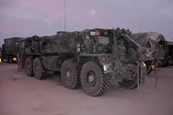 M984 Wrecker at dusk, recovery boom on the rear, bumper number YZ-92.